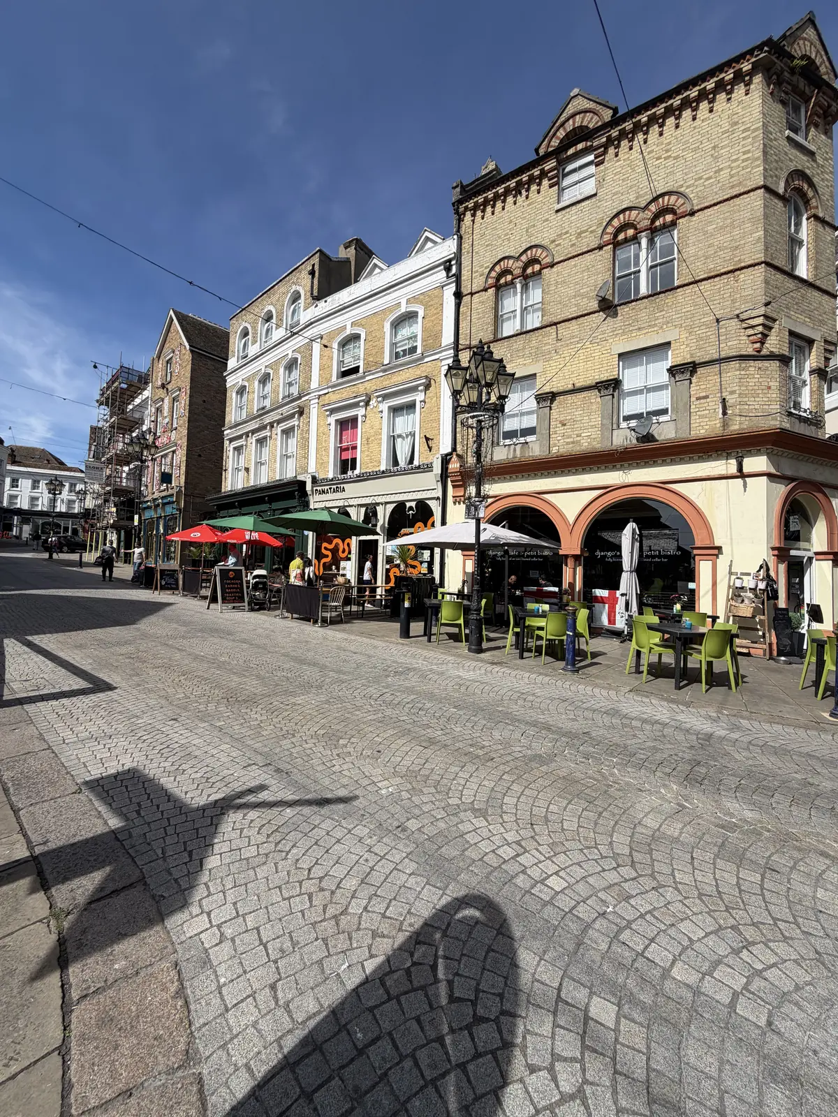 Folkestone town square with outdoor tables under a blue sky